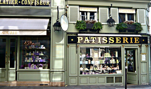 panadería clásica de Francia, con paredes de color verde claro y cartel de Patisserie en colores dorados y fondo negro