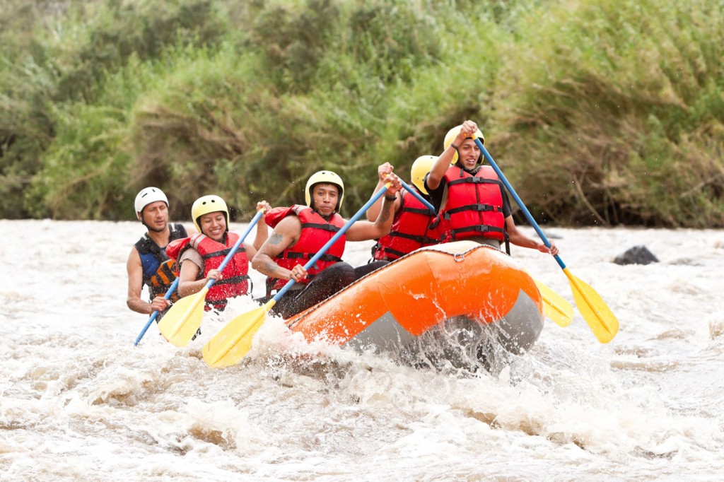 5 personas arriba de un bote haciendo rafting en un rio
