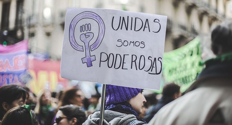 Protesta durante el 8m, una mujer con un cartel que dice "unidas somos poderosas"
