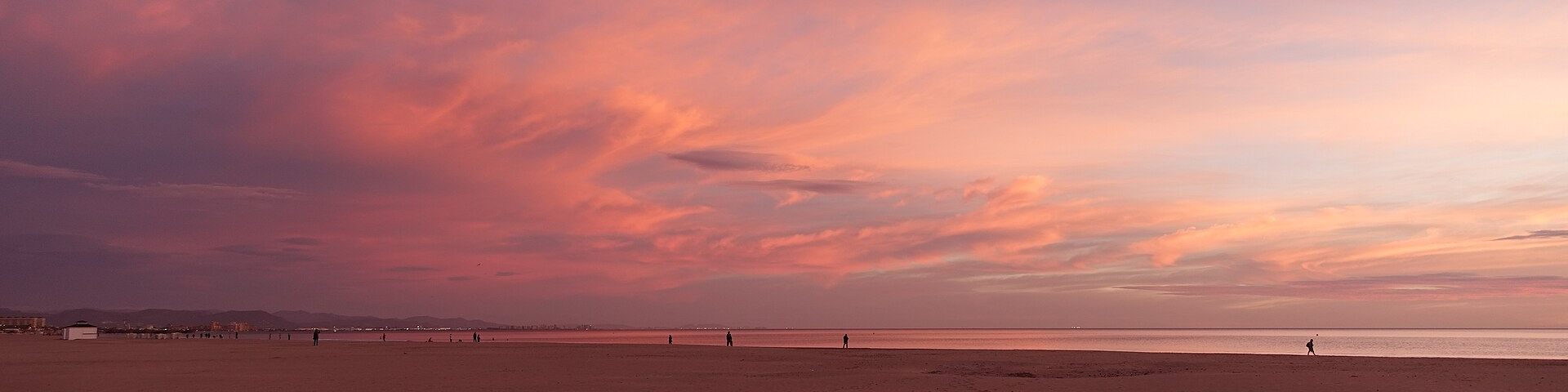Cielo rosado al amanecer sobre una playa de Valencia