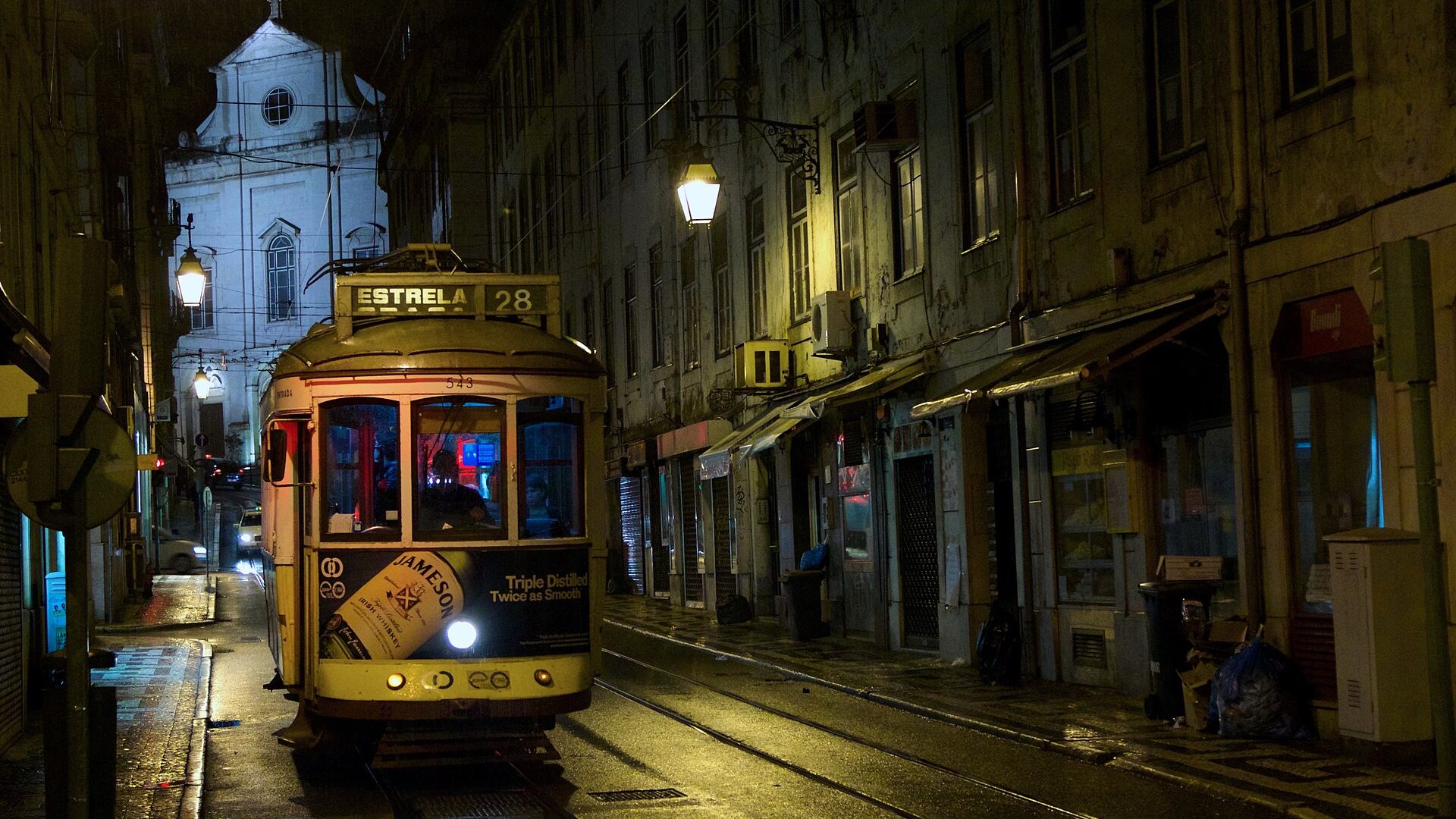 Tranvía 28 recorriendo de noche una calle de Lisboa