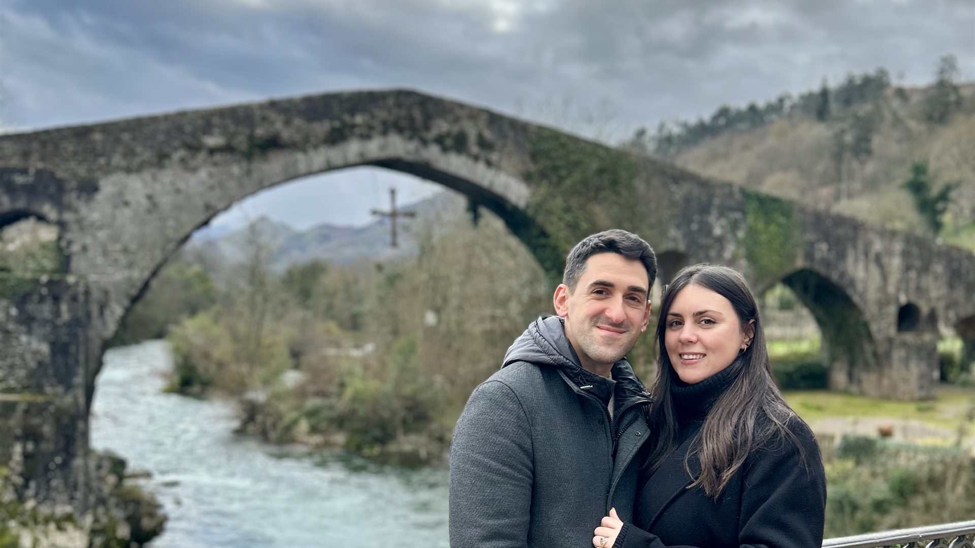 Pareja en el puente romano de Cangas de Onís, viajar fuera de temporada sin rutas turísticas
