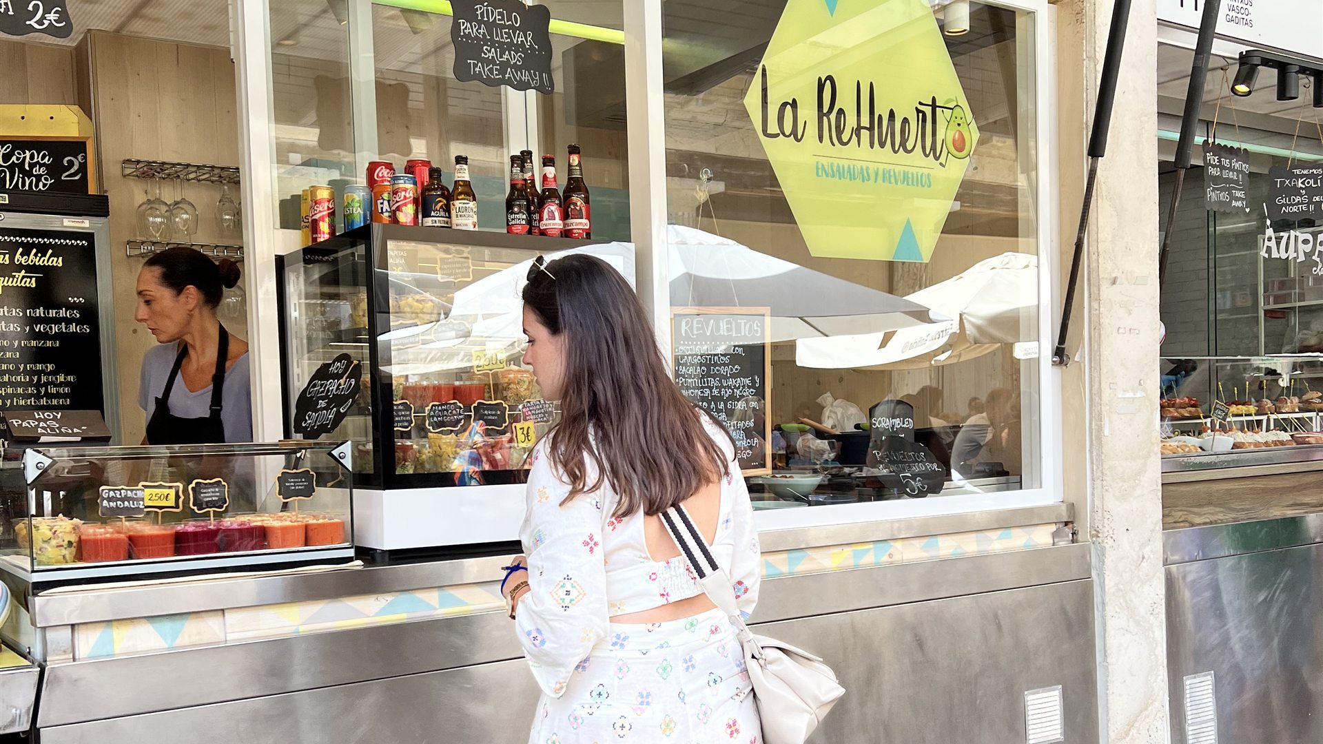 Viajera pidiendo recomendaciones en un puesto del Mercado de Abastos de Cádiz, experiencia auténtica
